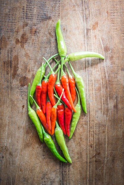 Rode en groene chili peper op een oude houten achtergrond