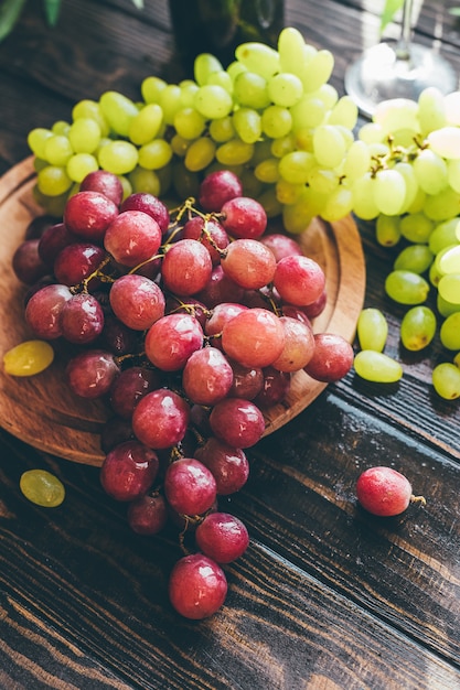 Rode en groene druiven op een houten tafel