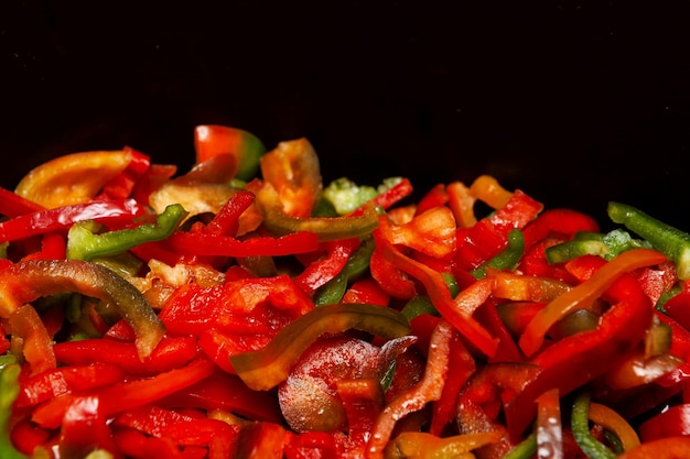 Foto rode en groene gesneden paprika's gebakken in pan selectieve focus kopieerruimte