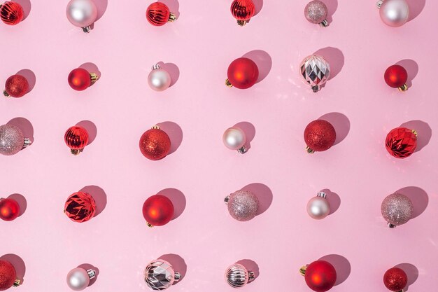Rode en roze decoratieve ballen op een roze achtergrond Bovenaanzicht plat gelegd