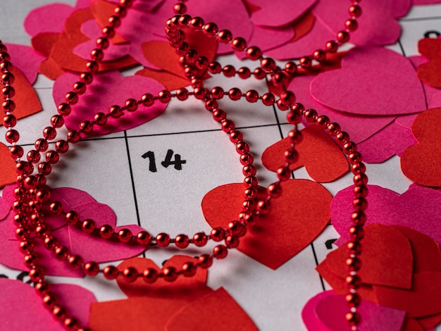 Rode en roze harten en lint op witte kalender met valentijnsdag