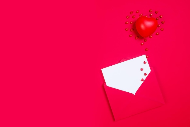 Rode envelop met witte papieren ansichtkaart mockup en harten voor Valentijnsdag