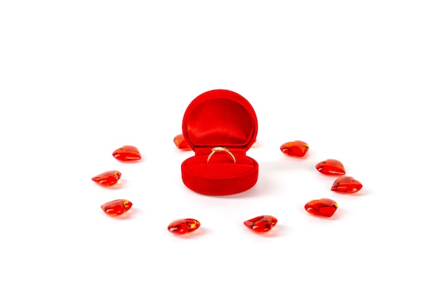 Rode fluwelen geschenkdoos met een diamanten ring en een hart op een witte muur. Valentijnsdag.