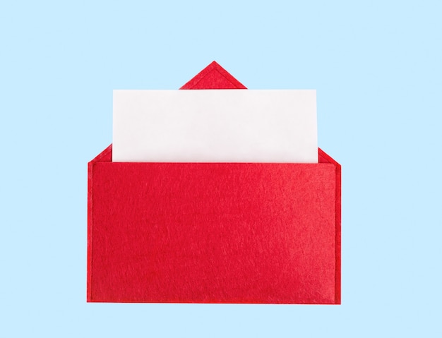 Rode geopende envelop met een vel papier op een blauwe achtergrond met copyspace. Valentijnsdag