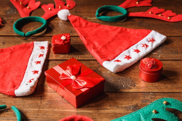 Rode geschenkdoos en kerstmuts op houten achtergrond