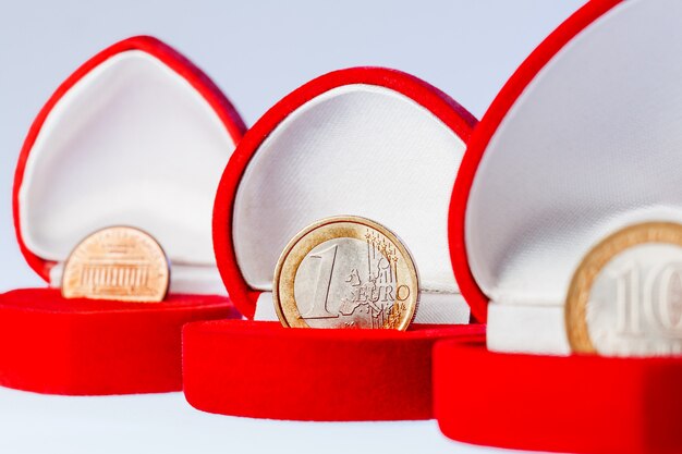 Rode geschenkdozen met één euro, tien roebels en munten van één cent. Focus op euromunt, de officiële valuta van de eurozone (Europese Unie).