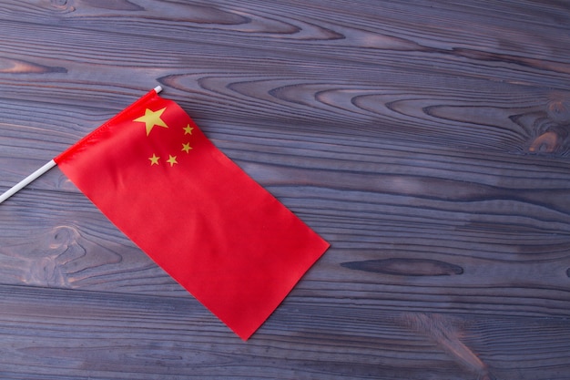 Rode golfvlag van China op grijze houten bureauachtergrond