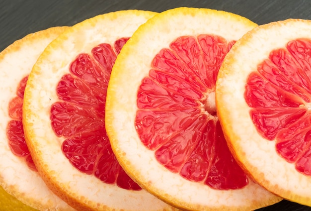 Rode grapefruit met sinaasappelschil close-up. Sectie van Sappig Bitterzoet Fruit. Gesneden Ruby Citrus