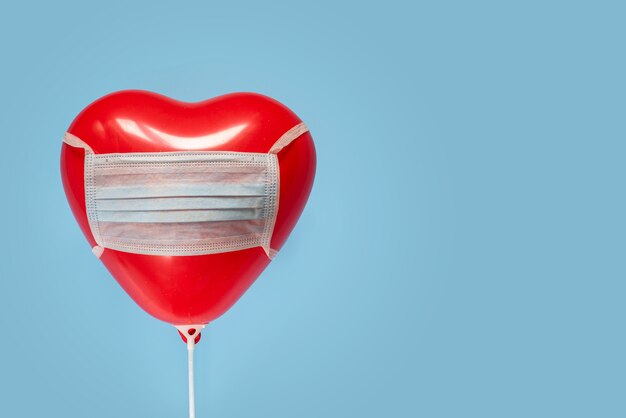 Rode hartballon in medisch masker, Valentijnsdag tijdens pandemisch concept