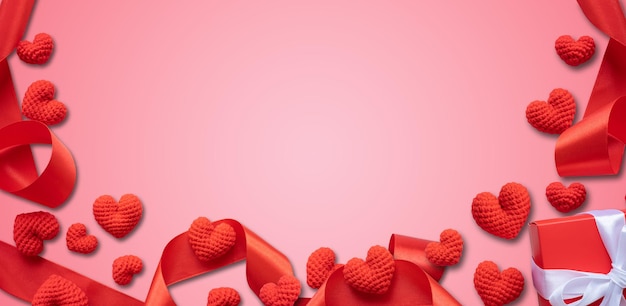 Rode harten en linten op pastelroze achtergrond Valentijnsdag