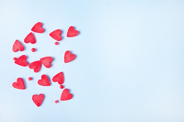 Rode harten kandijsuiker op de lichtblauwe achtergrond. Valentijnsdag concept. Bovenaanzicht. Kopieer ruimte.