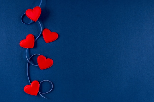 Rode harten met lint op klassieke blauwe 2020-kleurenachtergrond. Valentijnsdag 14 februari concept. Plat lag, kopie ruimte, bovenaanzicht, banner.