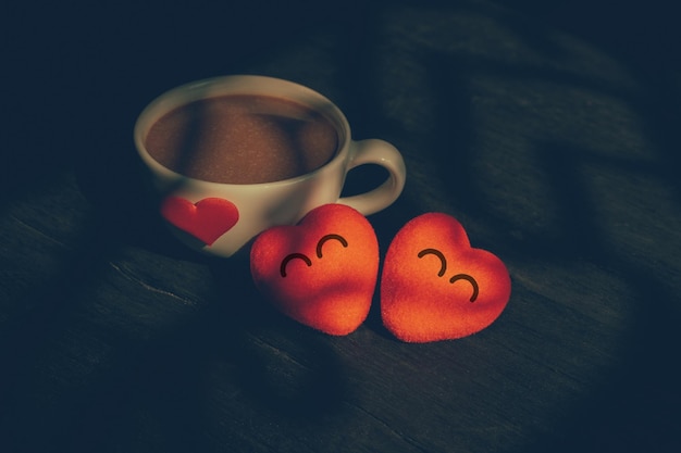 Rode harten zijn vrolijk en stijlvolle zwarte houten vloer koffiemok met hartjes. Ontbijt voor koppels