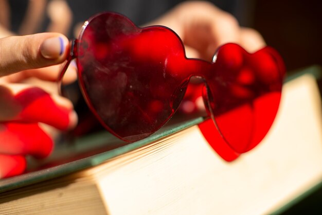 Rode hartvormige bril op een boek