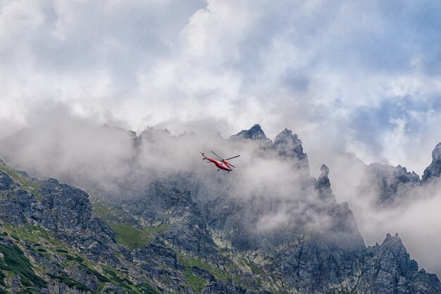 Foto rode helikopter die over de bergen tatra, polen vliegt.