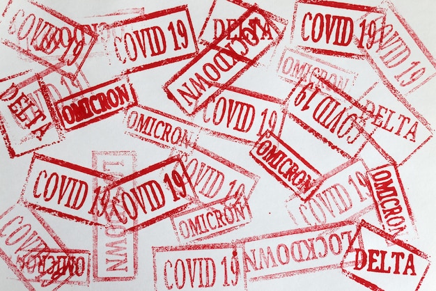 Rode inkt stempels covid19 en ommicron delta lockdown close-up achtergrond. Wereldwijd pandemie coronavirus infectie concept