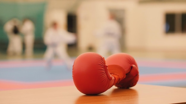 Rode karatehandschoenen op tatami tijdens training, onscherp, close-up