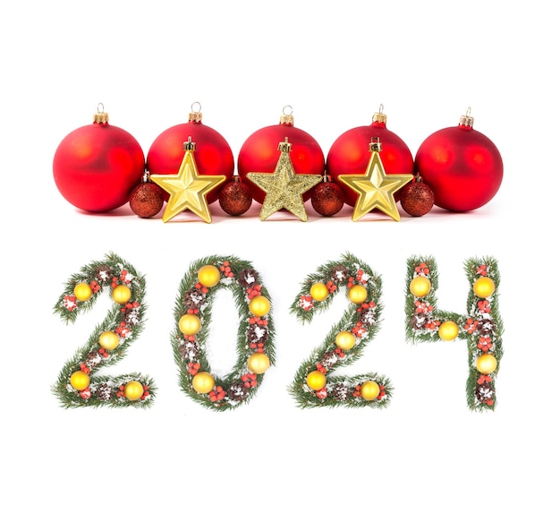 Foto rode kerstbal en 2024 nummer gemaakt door kerstboom takken geïsoleerd op witte achtergrond