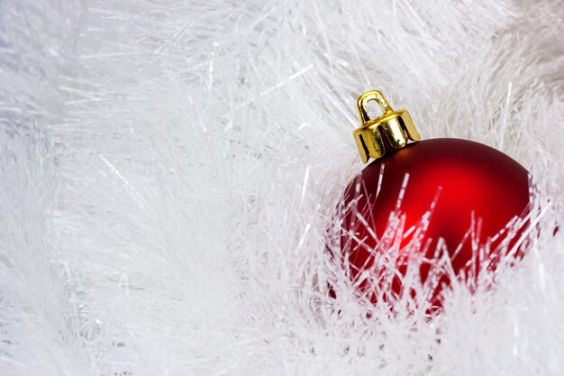 Rode kerstbal op de onscherpe achtergrond van klatergoud