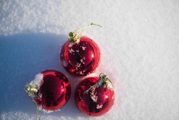 rode kerstballen met lange schaduwen in verse sneeuw op mooie zonnige winterdag