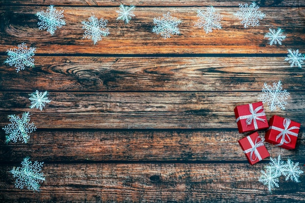 Rode kerstcadeaus op houten achtergrond met sneeuw
