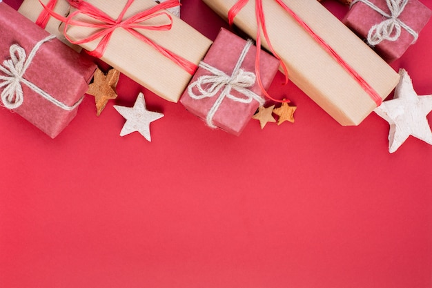Rode kerstversiering, fir tree takken met speelgoed geschenkdozen op rood