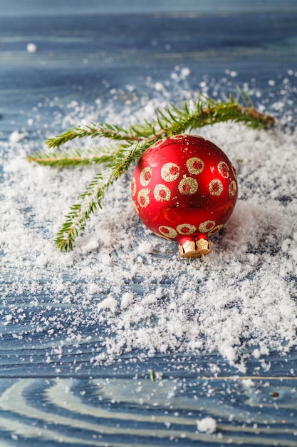 Rode kerstversiering op vuren takken met sneeuw