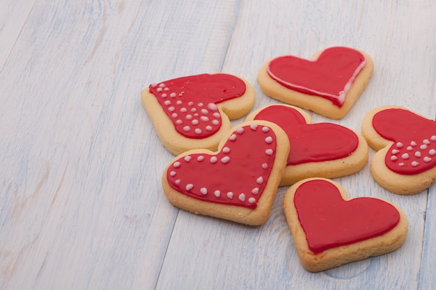 Rode koekjes in de vorm van een hart op houten planken close-up op Valentijnsdag