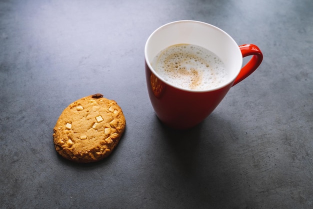 Rode koffiekop met chocoladekoekje op een tafel