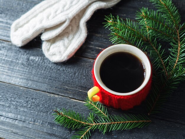 Rode kop koffie op een houten tafel met boomtakken