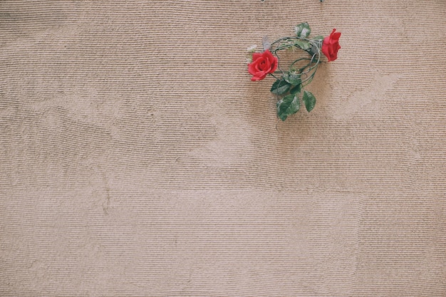 Rode kunstbloemen op de muur.