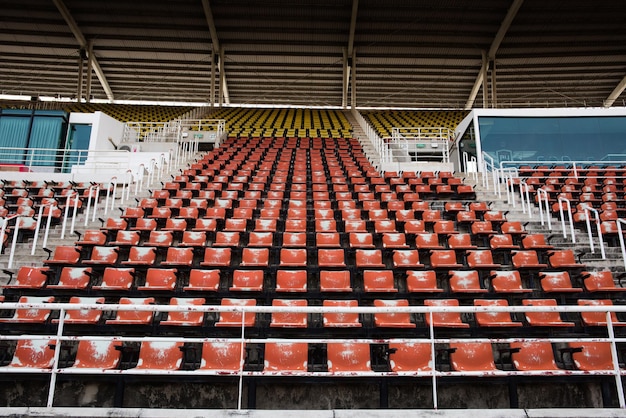 Rode lege en oude plastic stoelen in het stadion