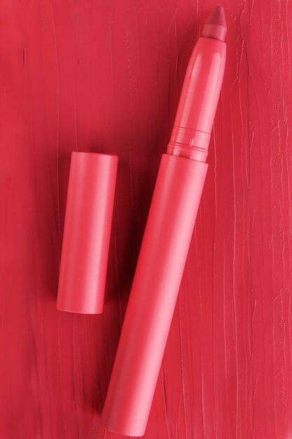 Rode lippenstift buis textuur, lipgloss close-up. Schoonheid industrie concept.