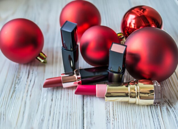 Rode lippenstift op een houten tafel met kerstversieringen