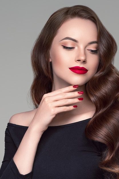 Rode lippenstift vrouw schoonheid krullend haar close-up gezicht mode portret