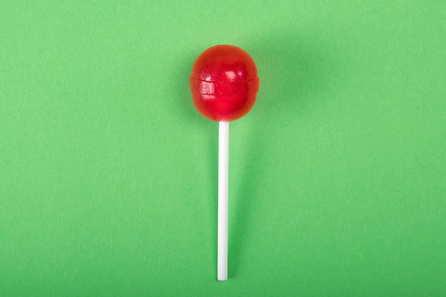 Rode lolipop op groen pastel achtergrond zoet suikergoedconcept