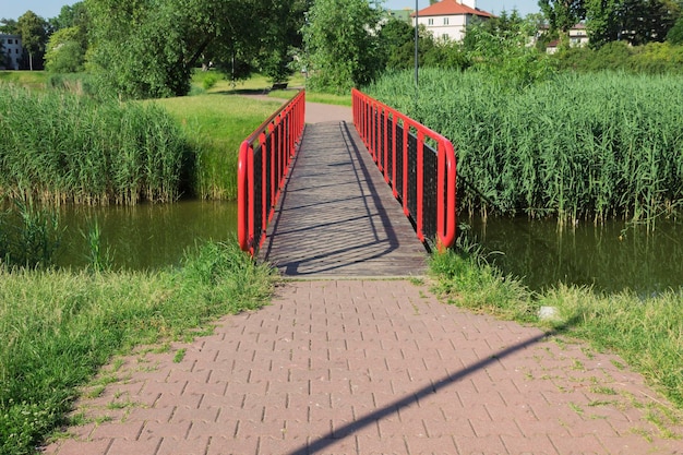 Rode metalen brug over de rivier Landschap en landschap