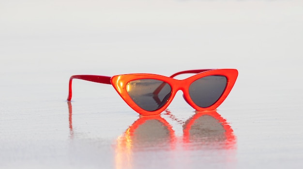 Rode mode zonnebril op zand mooi zomerstrand