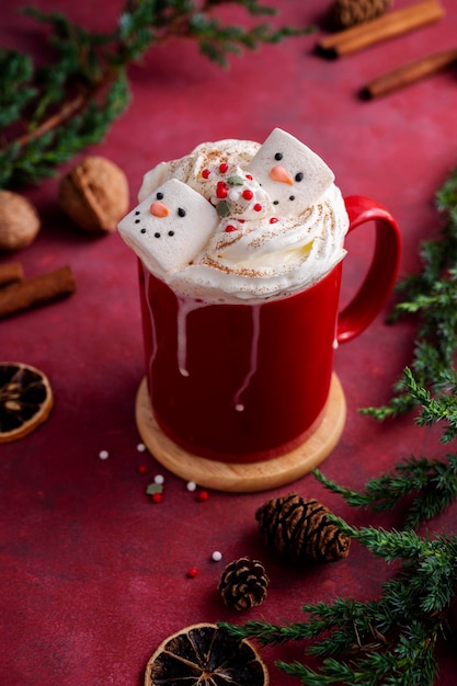 Rode mok met warme chocolademelk en gesmolten marshmallow sneeuwpop kleurrijke bourgondische feestelijke achtergrond