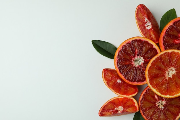 Rode oranje plakjes met bladeren op wit