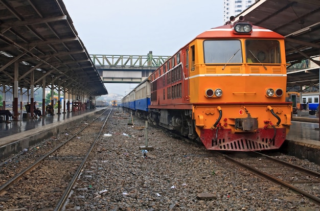 Rode oranje trein, Diesel locomotief, op het station van Bangkok van het platform Thailand