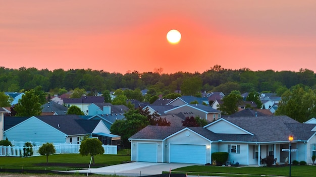 Rode oranje zonsopgang zonsondergang over voorstedelijke huizen in de buurt bos skyline lucht