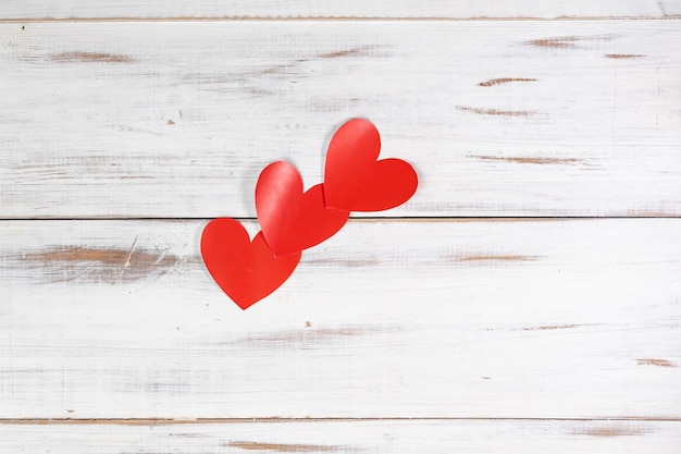 Rode papieren hartjes op een witte houten achtergrond Verklaring van liefde Valentijnsdag concept