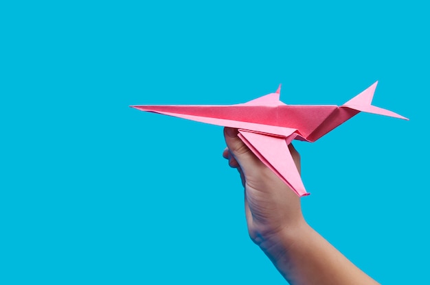 Rode papieren vliegtuigje ter beschikking op blauw