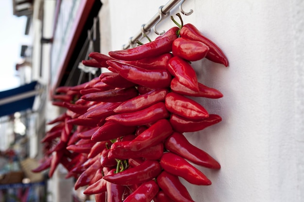 Rode paprika's hangen aan de voorkant van een supermarkt