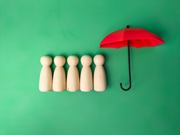 Foto rode paraplu met peg-pop-arrangement om houten peg-pop-plan te beschermen om het gezin te beschermen en risico's te voorkomen