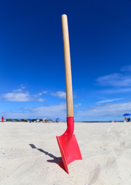 Foto rode paraplu op het strand tegen de blauwe hemel