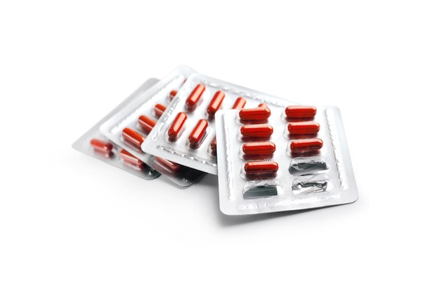 Rode pil capsules in blisterverpakkingen geïsoleerd op een witte achtergrond met uitknippad