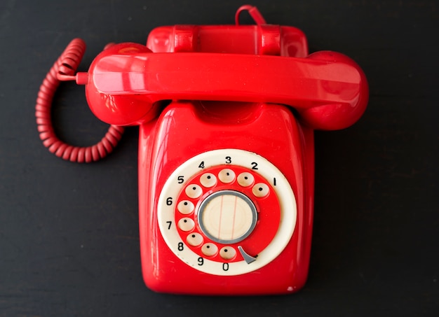 Rode retro vintage telefoon op zwarte achtergrond