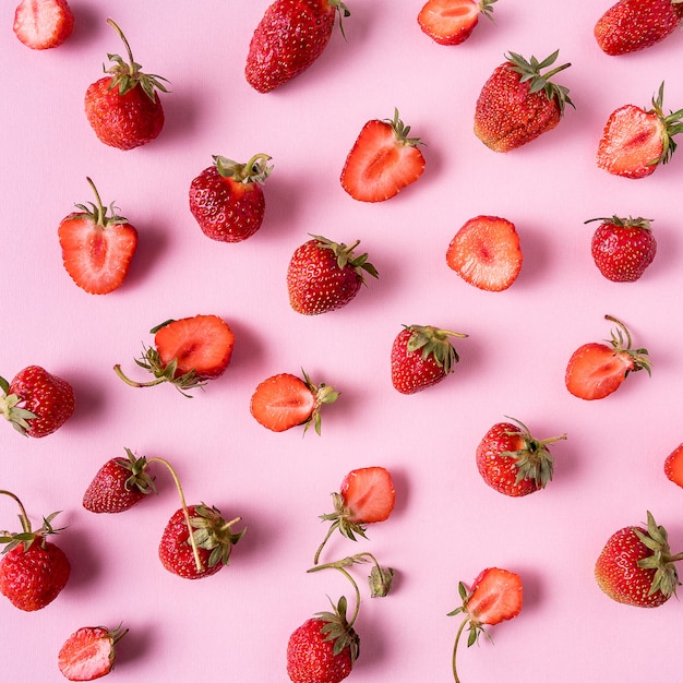 Rode rijpe aardbeien over roze, plat lag.